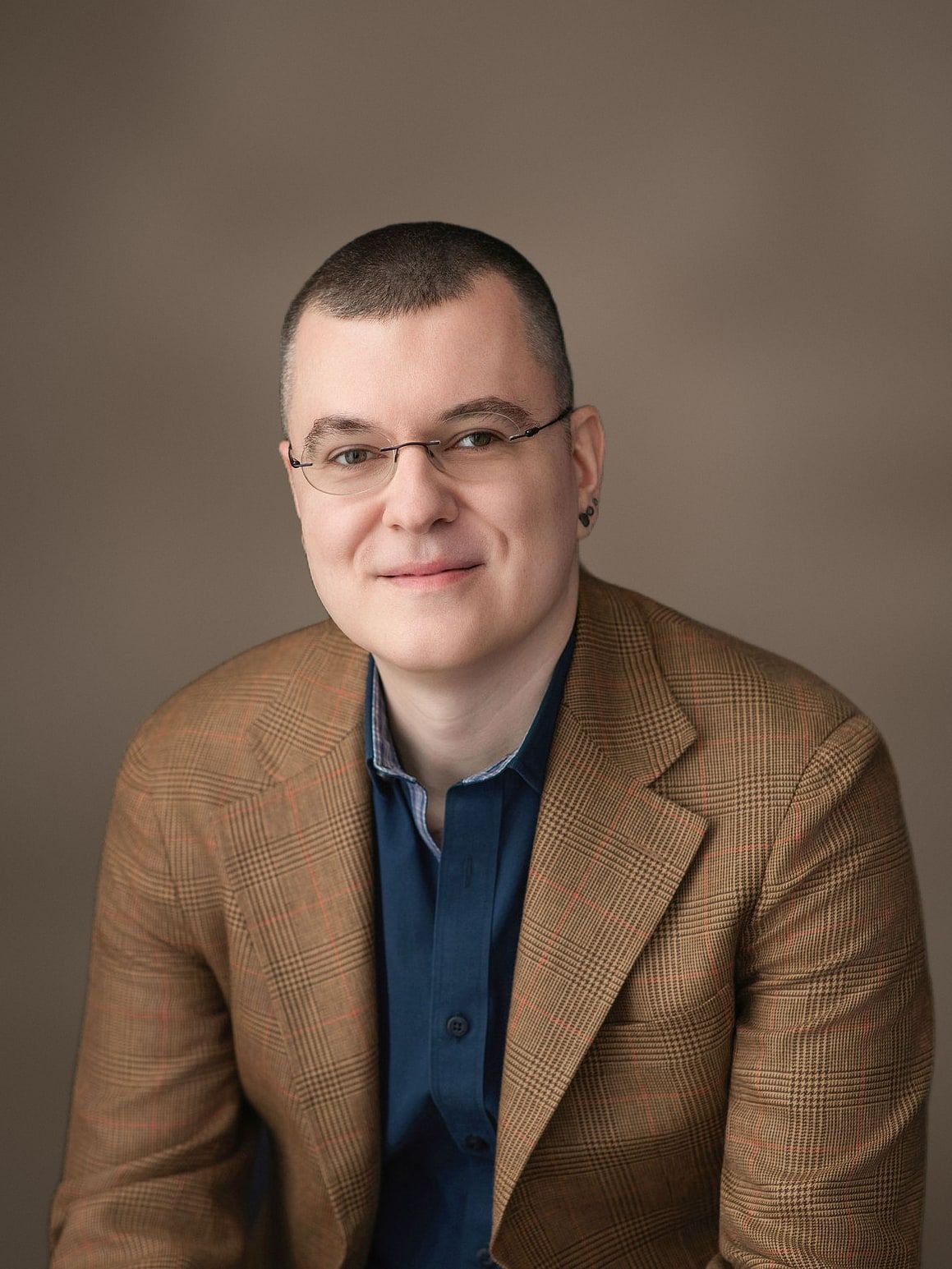 Kevin McElligott in a tan plaid blazer and navy shirt